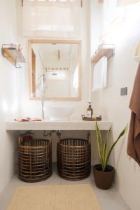 a bathroom with a sink and two baskets at Diwa Siargao Eco-House in General Luna
