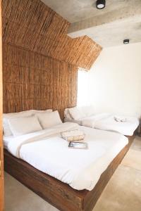 dos camas con sábanas blancas y un libro sobre ellas en Diwa Siargao Eco-House, en General Luna