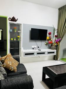 a living room with a tv on a wall at SA @ Cameron Emerald Avenue in Brinchang