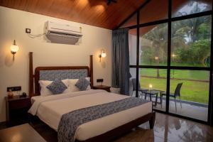 a bedroom with a bed and a large window at White Sand Beach Resort in Kondivli