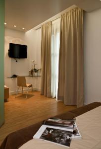 a hotel room with a bed with a television and a room with at Chic Hotel in Athens