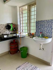 cocina con fregadero, ventana y encimera en Jestine Homestay, en Kochi