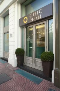 una entrada de hotel chik con dos macetas delante de ella en Chic Hotel, en Atenas