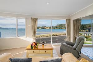 a living room with a view of the ocean at Waterfront Apartments Whitianga in Whitianga