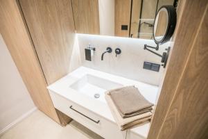 トルンにあるApartament Migdałowyの白い洗面台と鏡のあるバスルーム +21枚の写真