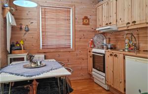 a kitchen with wooden walls and a table in a room at 3 Bedroom Beautiful Home In Flekkerøy in Ytre Skålevik