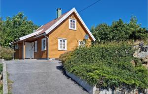 een houten huis met een oprit ervoor bij Amazing Home In Flekkery With Kitchen in Ytre Skålevik