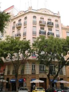 a large pink building with umbrellas in front of it at Young Penthouse in Valencia