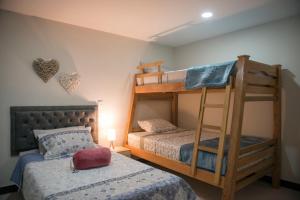 a bedroom with two bunk beds and a bed at Casa Tangara Café y Hospedaje in Medellín