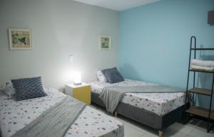 a bedroom with two beds and a shelf at Casa Tangara Café y Hospedaje in Medellín