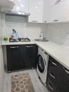 a kitchen with a sink and a washing machine at 2-х комнатная квартира in Tashkent