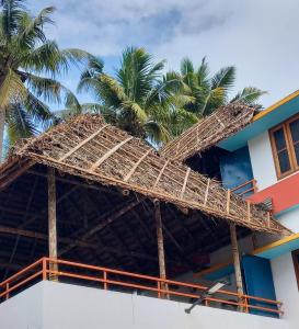 a building with palm trees on top of it at Madhav Mansion Beach Resort in Varkala