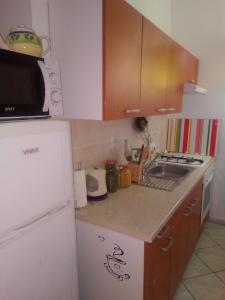 a kitchen with a white refrigerator and a sink at Apartments by the sea Brist, Makarska - 19330 in Podaca