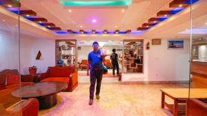 a man is walking through a living room at Hotel Blue Horizon in Kathmandu