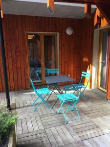 un patio con mesa y sillas en una terraza en Appartement en centre ville à 30m du télécabine, en Font-Romeu-Odeillo-Via