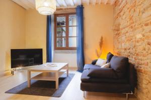 ein Wohnzimmer mit einem Sofa und einem Tisch in der Unterkunft Renaissance in Bourg-en-Bresse