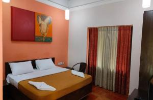 a bedroom with a bed and a window at Miramar Residency in Panaji