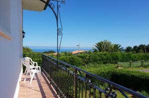 un balcón con una silla blanca y el océano en Casa rural Itxas Ertz, en Mendexa