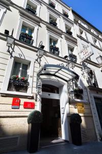 a white building with potted plants on the front at Arc Elysées in Paris