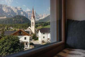 una vista da una finestra di una città con chiesa di Berghotel Sanví a San Martino in Badia