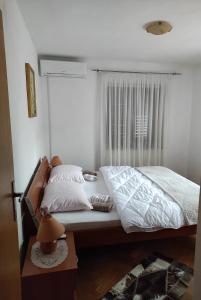 Schlafzimmer mit einem Bett mit weißer Bettwäsche und einem Fenster in der Unterkunft Rooms with WiFi Ston, Peljesac - 19339 in Ston