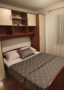 a small bedroom with a bed and shelves at Rooms with WiFi Ston, Peljesac - 19339 in Ston