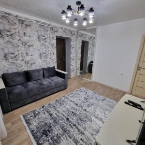 uma sala de estar com um sofá e uma parede de pedra em Квартира у моря em Aktau
