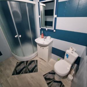 uma casa de banho com um WC, um chuveiro e um lavatório. em Квартира у моря em Aktau