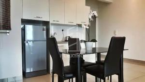 a kitchen with a table with chairs and a refrigerator at 1-2 Guests, HBO-GO TV, Bali-Style Studio in Cybersquare, Cyberjaya by Flexihome-MY in Cyberjaya