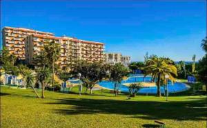ośrodek z basenem i palmami w parku w obiekcie Mediterránean & Sun in Minerva, Benalmádena w mieście Benalmádena