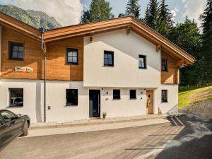 a house in the mountains with a car parked in front at Luxurious holiday home with sauna in Krimml