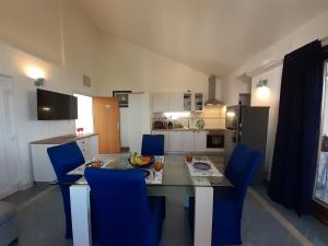a kitchen with a dining table and blue chairs at Apartments by the sea Vantacici, Krk - 19306 in Malinska