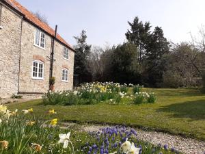 un giardino di fiori di fronte a un edificio di Characterful Cottage adjacent to an Orchard a Brockley