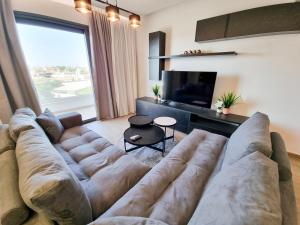 a living room with a large couch and a television at Lucky Strike Apartment in Nicosia