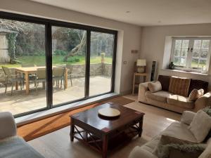 a living room with a large window and a table at Characterful Cottage adjacent to an Orchard in Brockley