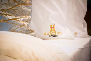a bed with a white pillow with a hilton sign on it at Hotel Horizon Entebbe in Entebbe