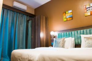 Habitación de hotel con 2 camas y cortinas azules en Hotel Horizon Entebbe en Entebbe