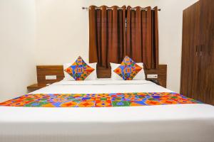 a bedroom with a bed with a colorful quilt on it at FabHotel Balaji Paradise in Indore