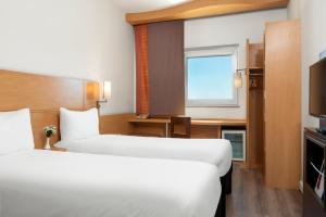 a hotel room with two beds and a television at Ibis Gaziantep in Gaziantep