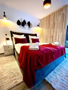 a bedroom with a large bed with a red blanket at Dream Studio Silver Mountain in Poiana Brasov