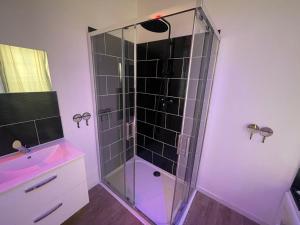 una doccia con cabina in vetro in bagno di NG SuiteHome - Lille I Tourcoing Winoc - Balnéo - Netflix - Wifi a Tourcoing