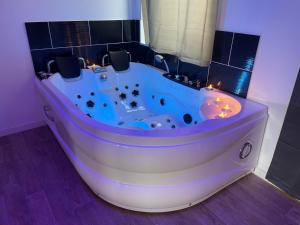 a white bath tub with lights in a bathroom at NG SuiteHome - Lille I Tourcoing Winoc - Balnéo - Netflix - Wifi in Tourcoing
