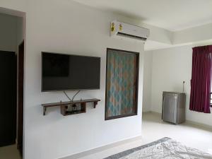 a white room with a tv on a wall at Hotel Wave Morjim in Morjim
