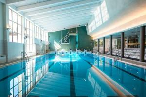 a large swimming pool with blue water in a building at Premium Chalet 4109 Blue in Vierumäki