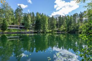 a view of a lake with trees and a house at Premium Chalet 4109 Blue in Vierumäki