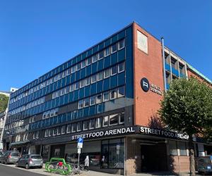 een gebouw in een stadsstraat met een straat foodospital bij Hotell Arendal in Arendal