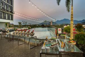 um resort com uma piscina e uma mesa com bebidas em Swiss-Belinn Singkawang em Singkawang