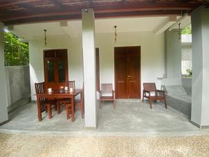 a patio with a table and chairs on a house at The Cozy Nest in Hikkaduwa