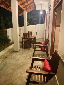 d'une terrasse avec des bancs, une table et des chaises. dans l'établissement The Cozy Nest, à Hikkaduwa