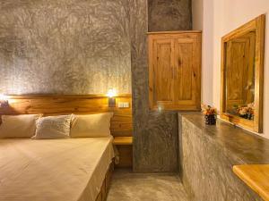 1 dormitorio con 1 cama y pared de madera en The Cozy Nest en Hikkaduwa